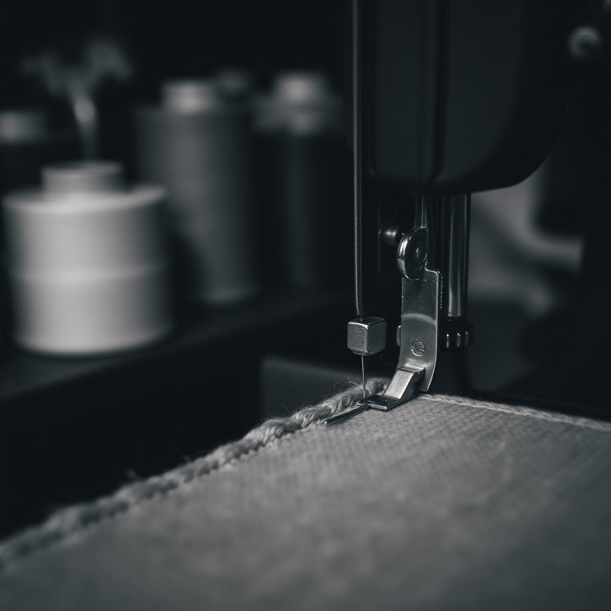 A sewing machine stitching wool fabric